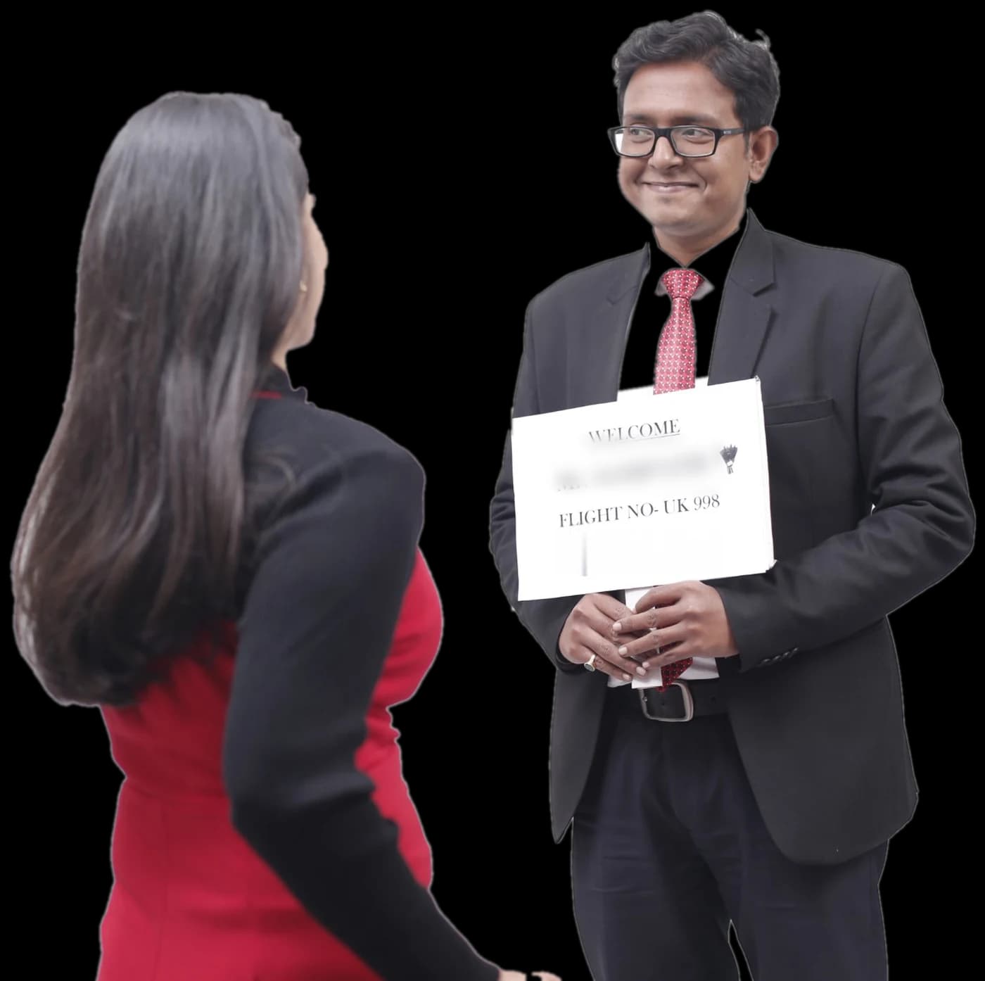 An Elite World Services greeter in a dark suit holds up a printed welcome name board as an arriving traveller walks up to meet him