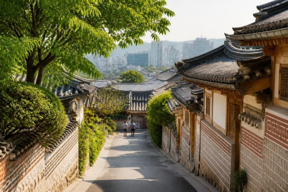 A lane of traditional hanok houses under green trees in Seoul in summer